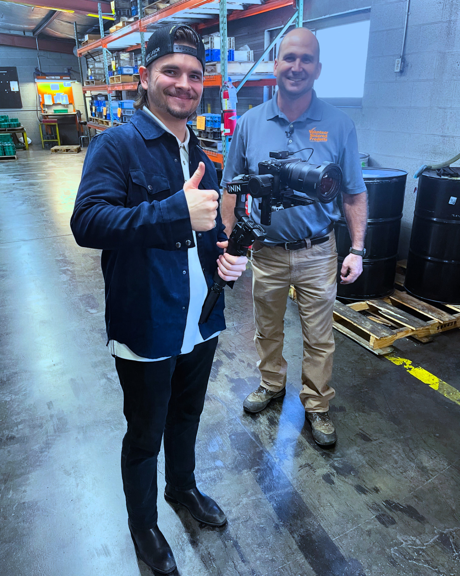 Hard Labor Marketing videographer with a gimbal camera standing beside the VSP owner on the plant floor
