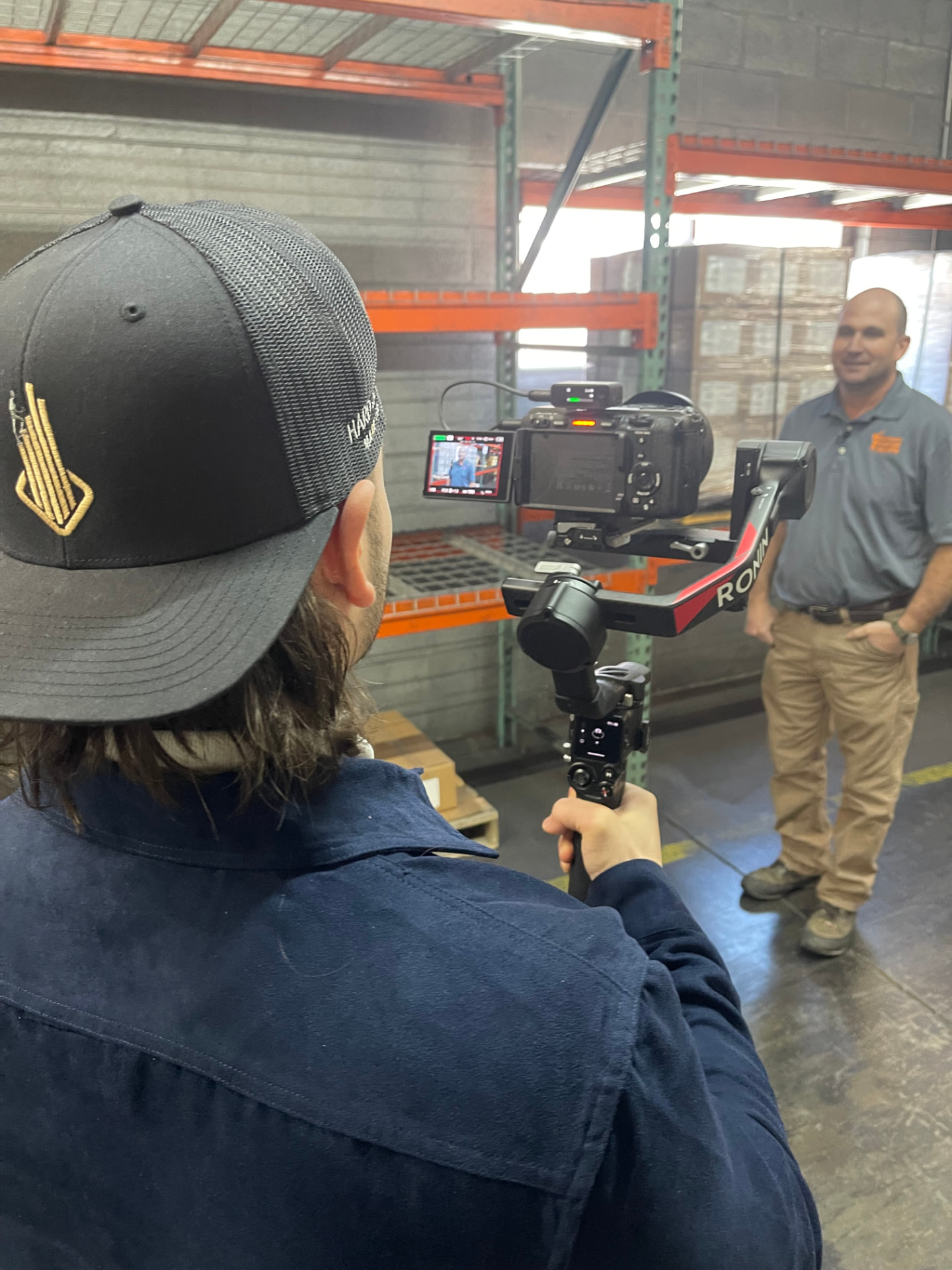 Over the shoulder view of a gimbal camera monitor framing a VSP leader for an on-camera interview