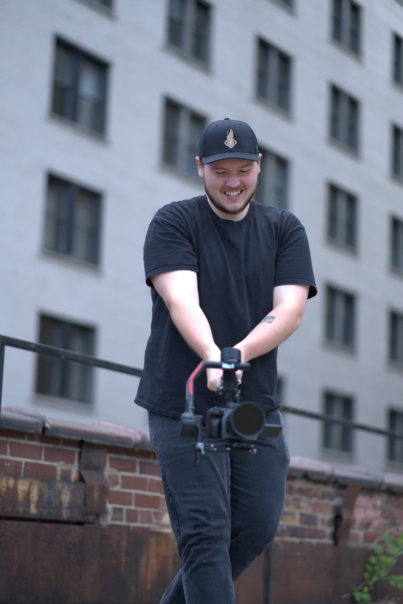 HLM videographer operating a gimbal on a downtown rooftop