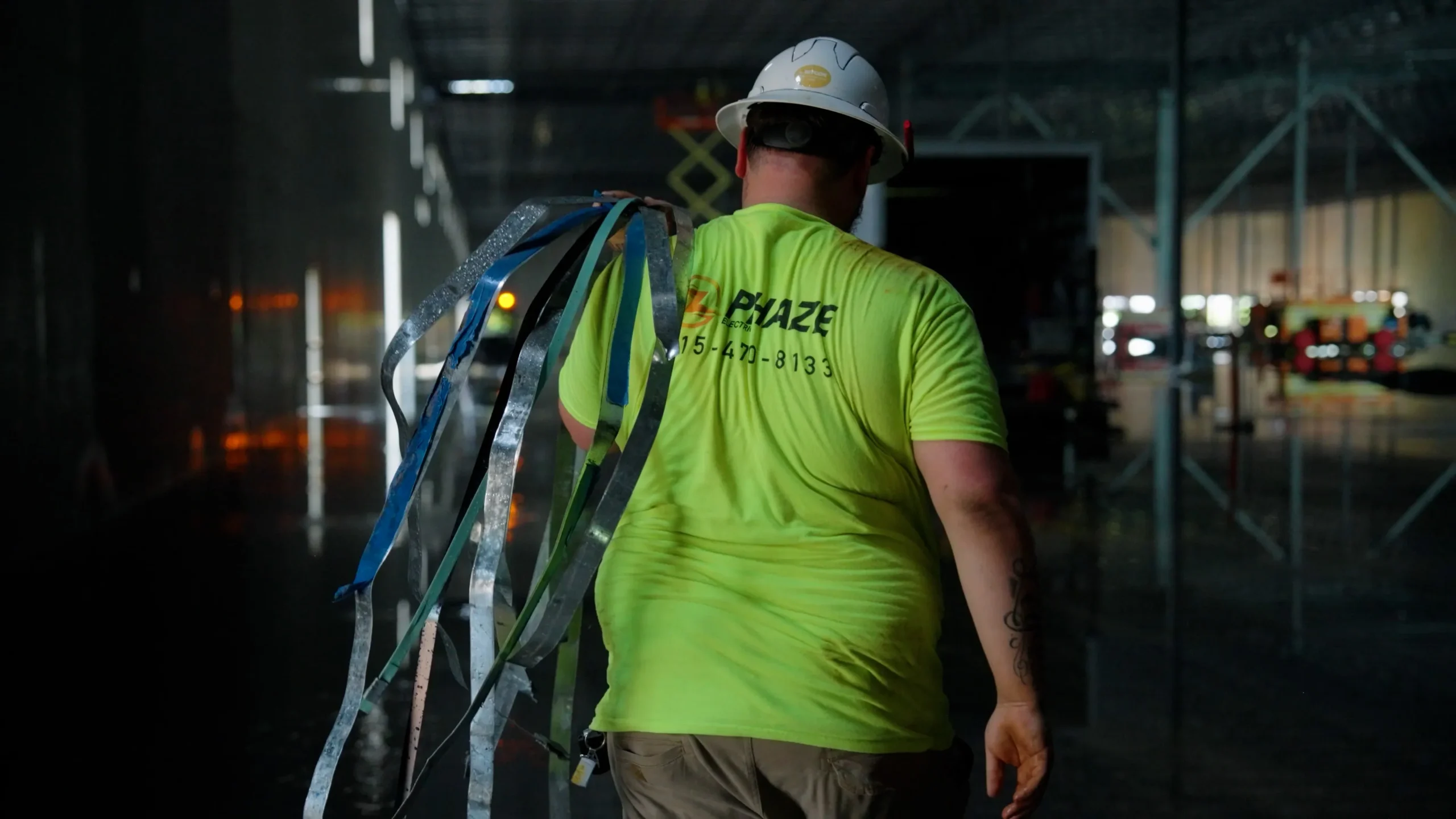 Phaze Electric electrician carrying wire across a jobsite