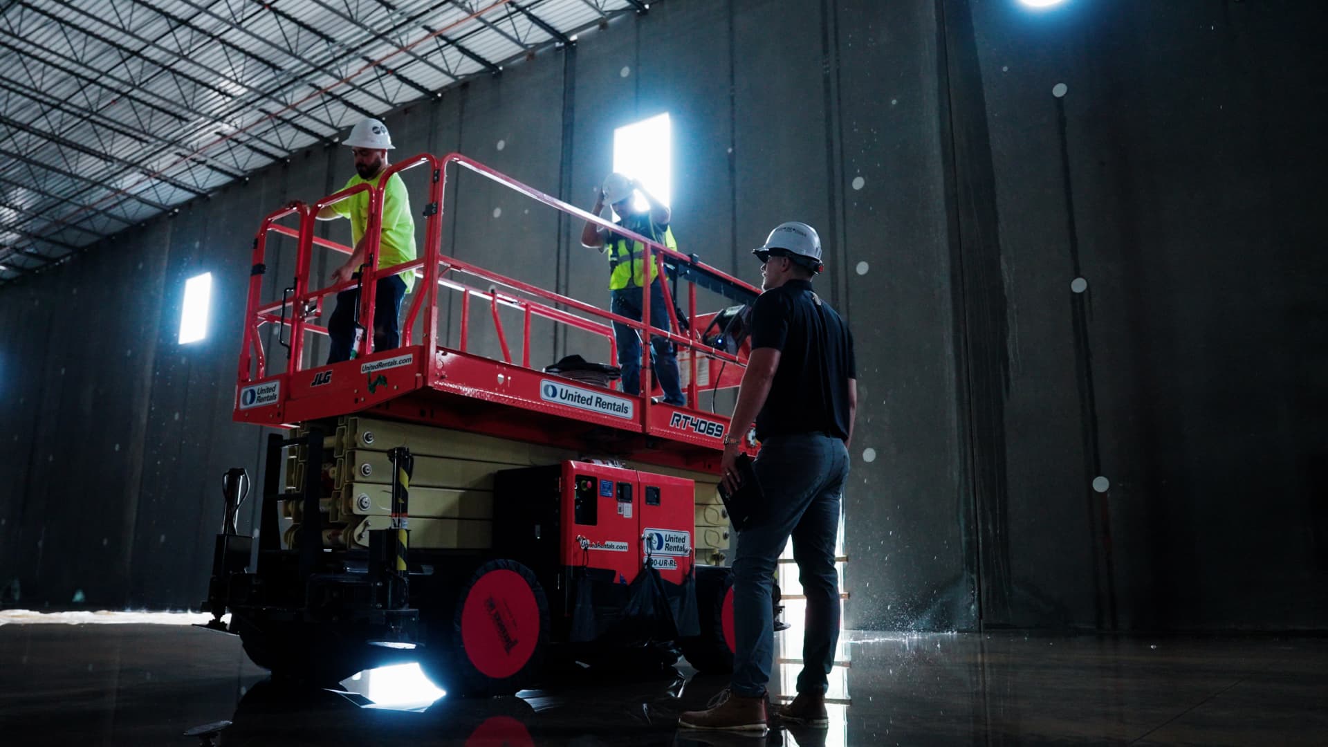 Hard Labor Marketing team member on a warehouse floor in Lebanon, Tennessee while Phaze Electric electricians work from a scissor lift overhead