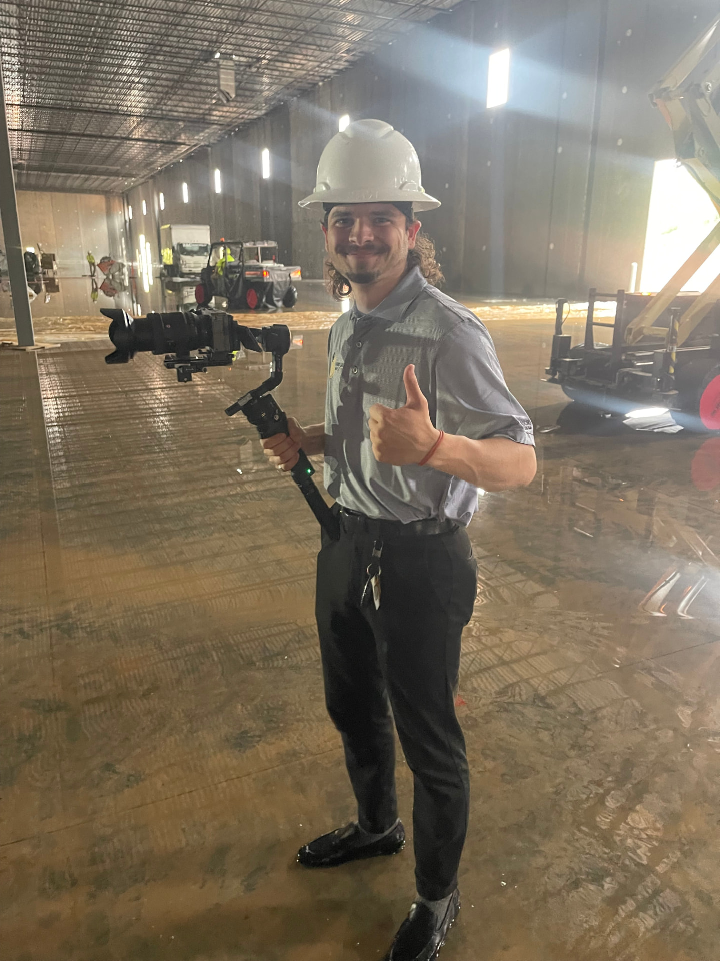 Hard Labor Marketing videographer with a gimbal camera rig on the Phaze Electric job site floor