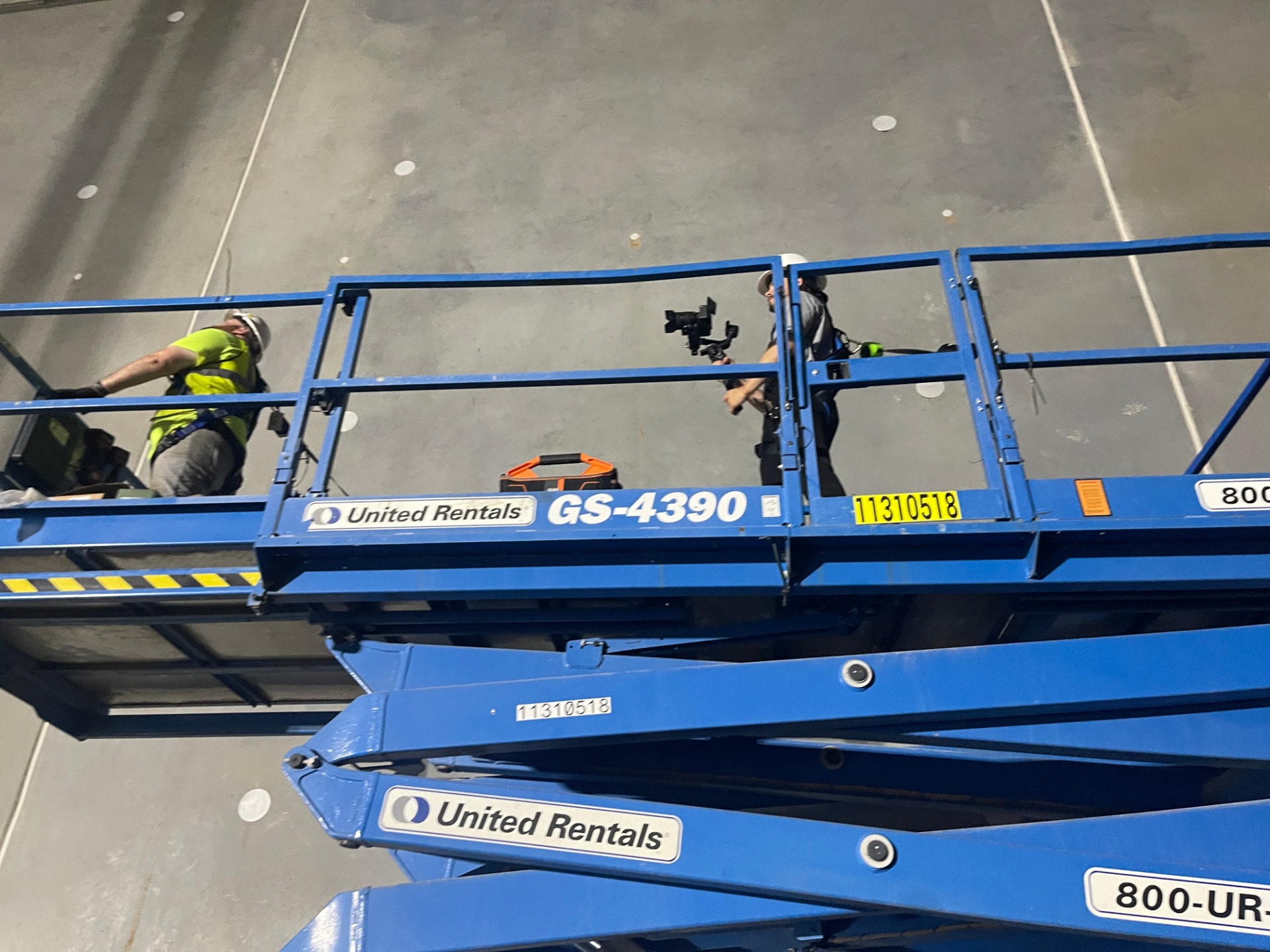 Hard Labor Marketing videographer filming from a scissor lift beside a Phaze Electric electrician working overhead