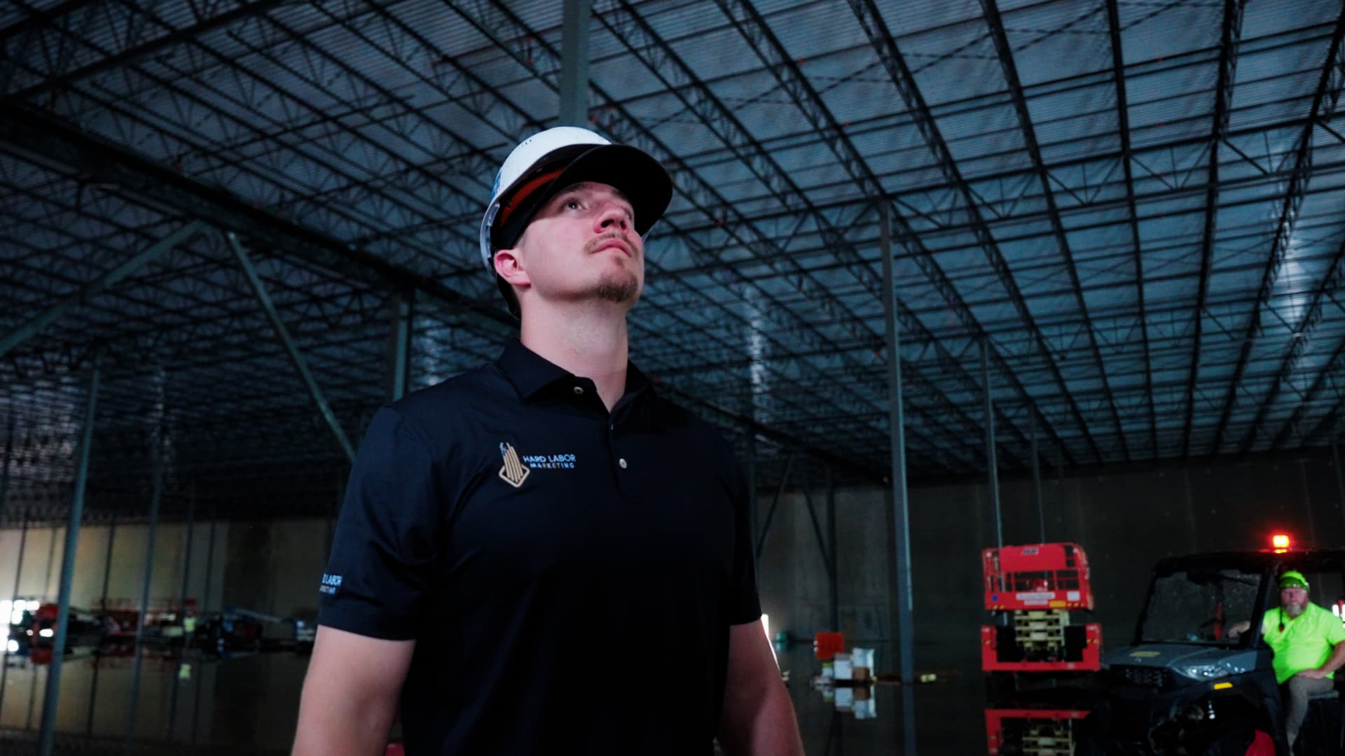 Hard Labor Marketing team member in a hard hat and branded polo inside the industrial building Phaze Electric was wiring