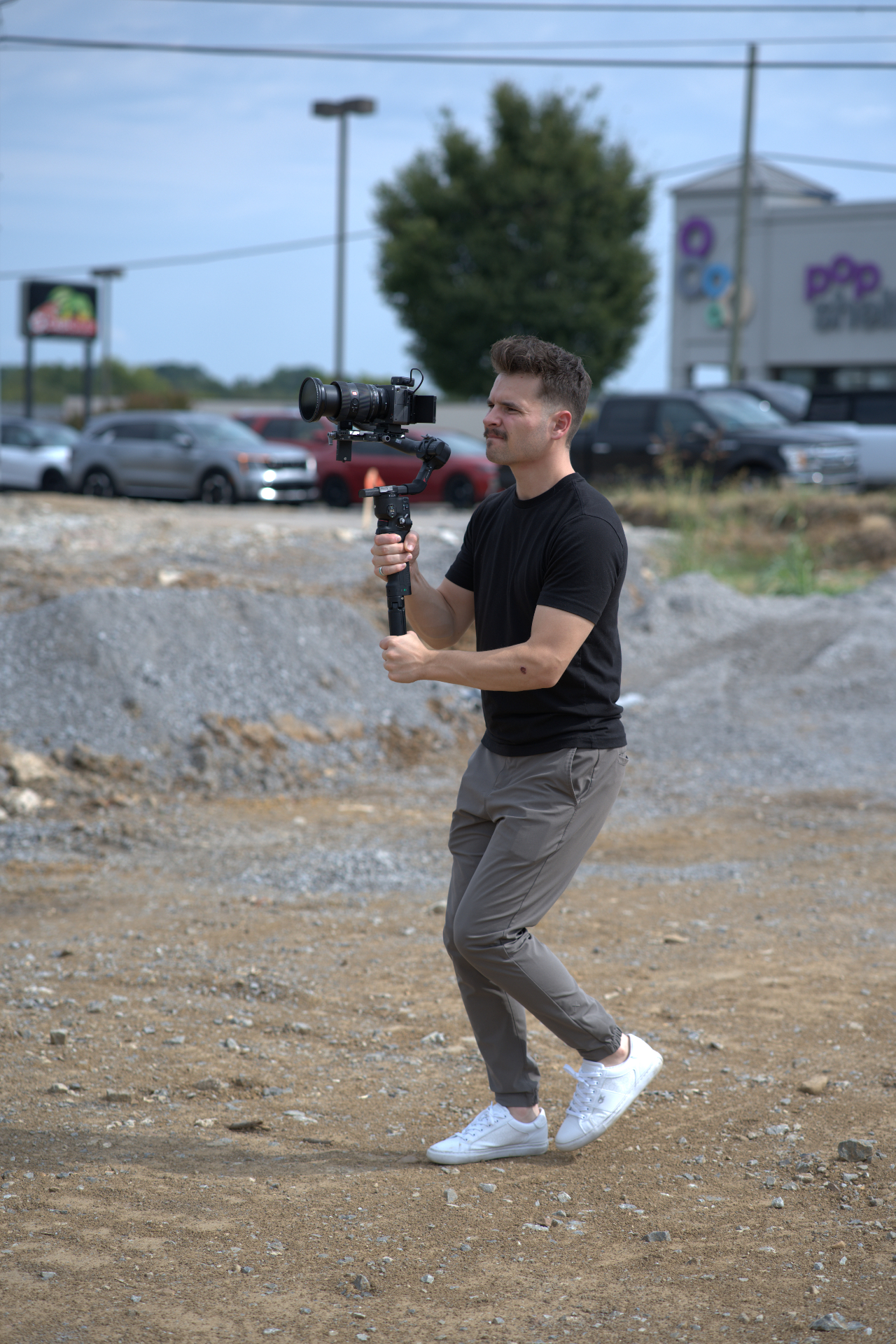 HLM videographer moving through a dirt lot with a gimbal rig